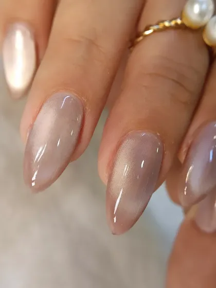 A close-up of a beautiful nude cat-eye nail. This almond-shaped nail shows how the effect can be subtle yet incredibly elegant, perfect for everyday wear.