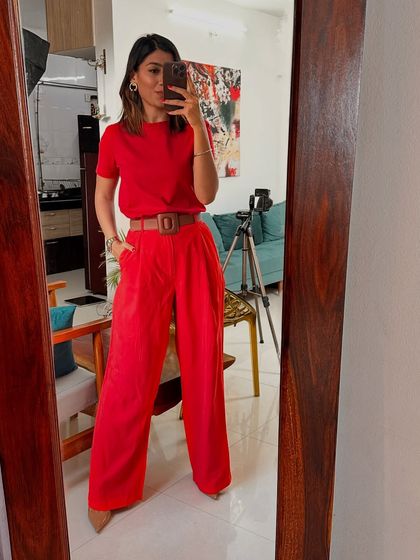 Creating a monochrome look with the red trousers and a matching red t-shirt, cinched with a belt for a sleek and powerful silhouette.