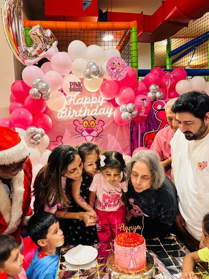 The whole family gathers to sing and blow out the candles on the Pink Panther birthday cake. It’s a heartwarming scene full of love and celebration.