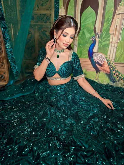 A full shot of a gorgeous green lehenga look. The makeup is kept soft and glowing to balance the heavily embellished outfit.