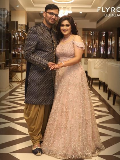 This couple is the definition of elegance. Her blush pink off-shoulder gown and his patterned Indo-western sherwani are a perfect match for a reception or engagement party.