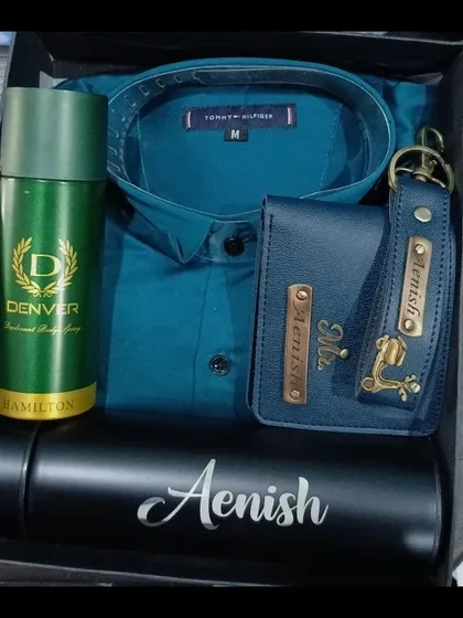 A handsome teal-themed gift hamper featuring a personalized temperature bottle, a matching wallet and keychain, a shirt, and deodorant.