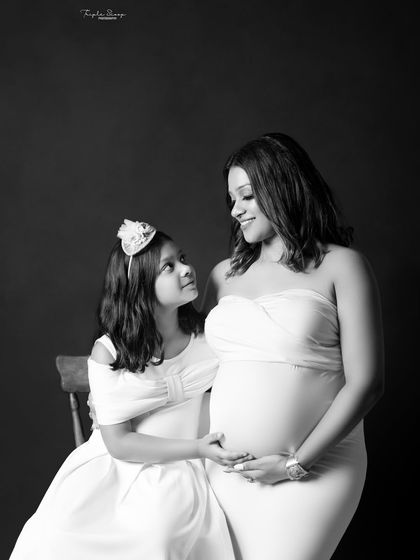 A touching black and white portrait of a mother and daughter sharing a quiet moment before the new baby arrives.