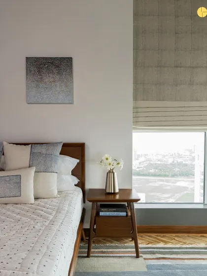A bedroom with a view. The design prioritizes the connection to the outdoors, with a large window framing the landscape. The use of natural wood and a simple color palette ensures the focus remains on the scenery.