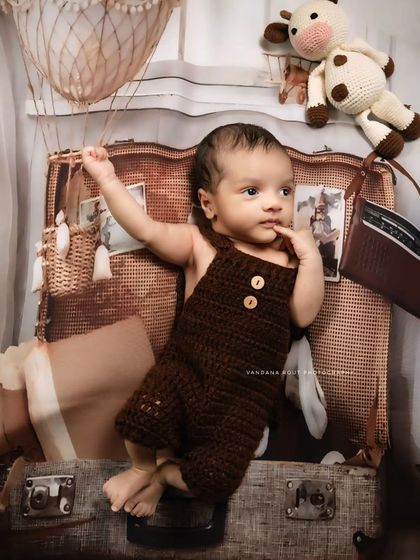 Here is another take on the traveler theme, with the baby looking thoughtful and ready for an adventure. The detailed props and textures in this newborn setup add a rich, narrative quality to the photograph.