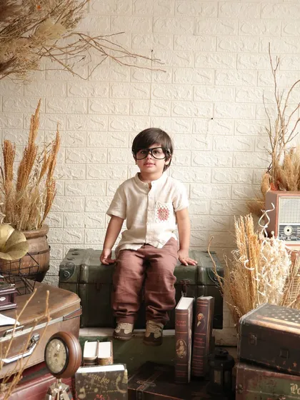 A young boy poses confidently in a vintage-themed setup for his third birthday. This shows my work with older toddlers, capturing their growing personalities.