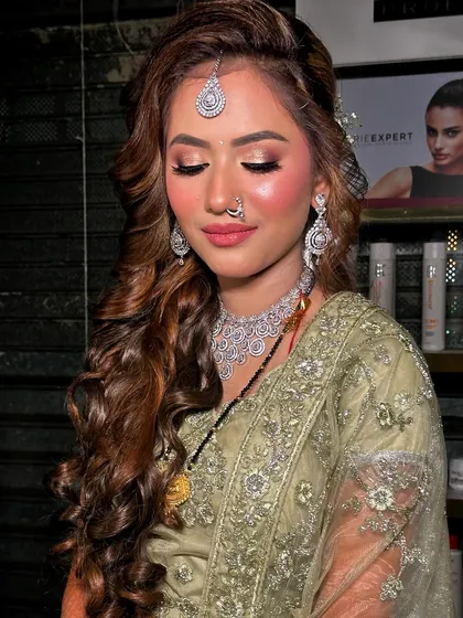 This reception look is all about confidence. The soft curls, glowing skin, and defined eyes come together for a look that is both glamorous and sophisticated.