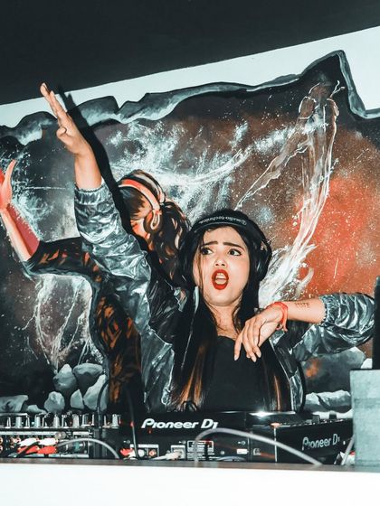 A high energy pose in front of a dynamic backdrop, capturing the wild spirit of my DJ sets.