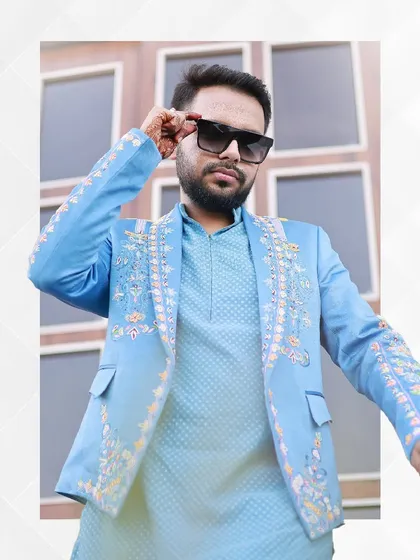 Confidence and style personified. This groom wears our sky-blue embroidered jacket and kurta set, a perfect choice for pre-wedding festivities that call for a celebratory and modern ethnic look.