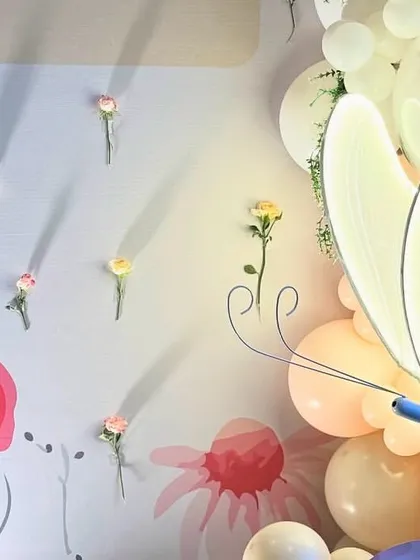 We love adding unique elements like this illuminated butterfly prop and a wall of single-stem flowers to make the decor truly special.