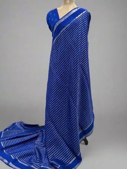 A mannequin draped in a royal blue saree with silver stripes.