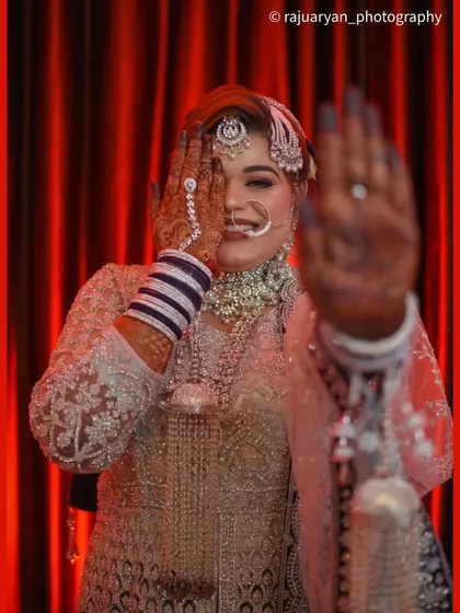 A playful and candid moment with a beautiful bride. This shot captures her genuine smile and personality, showing the intricate henna design on her hand, adding a modern and joyful feel to her bridal portraits.