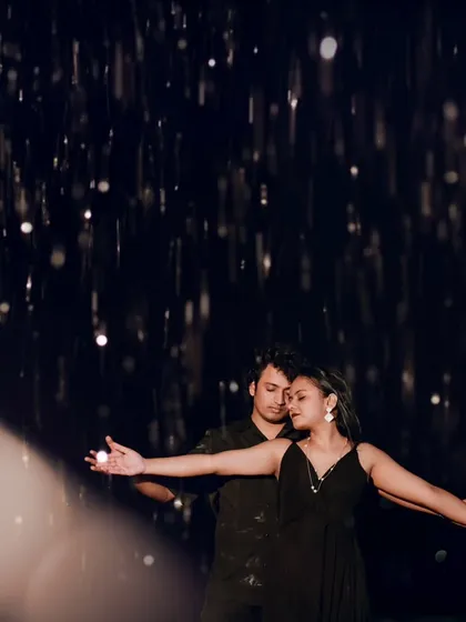 A couple embraces under a shower of rain during a dramatic night shoot in Goa. This creative shot uses lighting to turn the rain into sparkling jewels, creating a magical, cinematic feel.