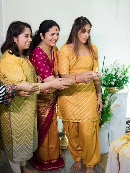 A closer view of the Haldi application, a moment of tradition and fun. The simple elegance of the decor keeps the focus on the people and the rituals.