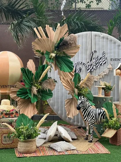 A different take on the "Wild One" theme, this setup includes a hot air balloon prop, vintage-style suitcases, and a zebra statue. The boho-chic style is perfect for a stylish first birthday.
