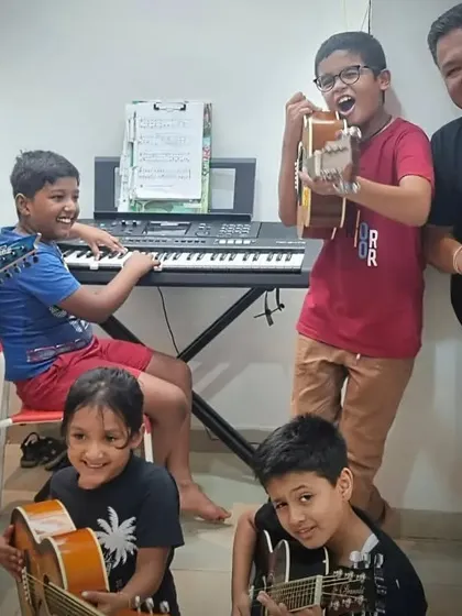 The jam session is in full swing. This photo captures the fun and energetic atmosphere as I play with a group of our young students on electric guitars, acoustic guitars, and a keyboard.