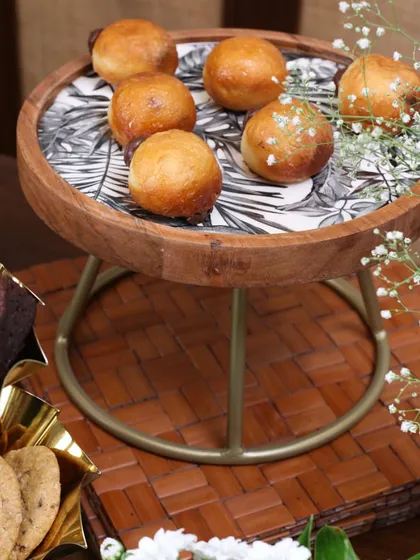 A close-up of our wooden cake stand with a monochrome leaf-print top. It’s a versatile piece that adds a touch of rustic modernity to any dessert spread, perfect for hosting with style.