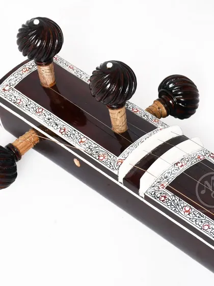 The headstock of the flat wooden tanpuri, with its carved rosewood pegs. These details ensure the instrument is easy to tune and holds its pitch well.