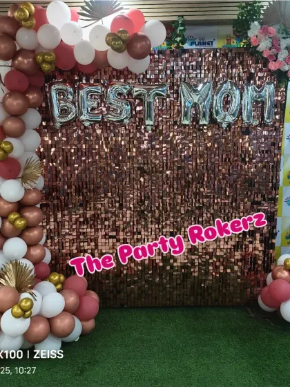 The complete "BEST MOM" photo booth for a Mother's Day event, with a sequin wall, balloon arch, and floral accents.