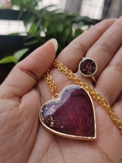 This matching jewelry set, a heart-shaped pendant and a ring, was created using a client's preserved rose petals. It's a beautiful way to keep a sentimental flower close to your heart.