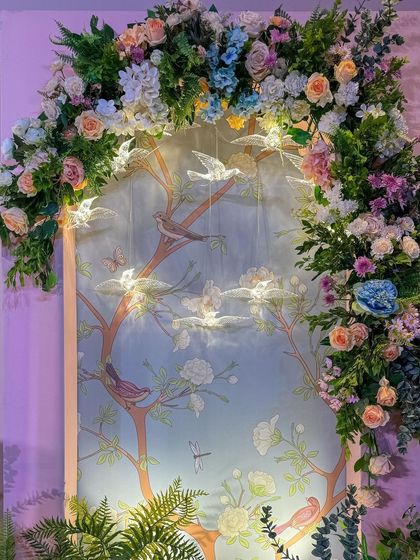 The beautiful floral arch with hanging glass birds, a whimsical and delicate detail for a baby's naming ceremony.