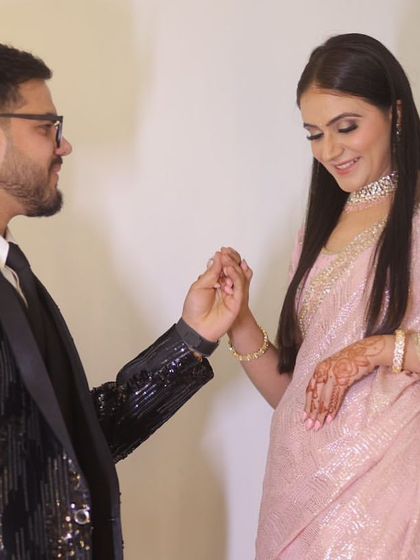 A beautiful couple on their engagement day. The bride's soft pink saree and subtle makeup create a romantic look.