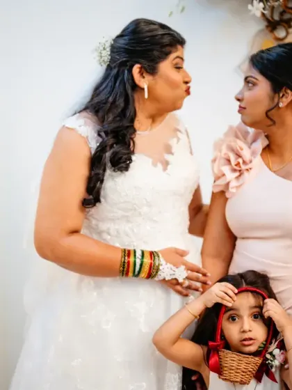 A funny face-off between the bride, her bridesmaid, and a very curious flower girl. Kids always bring an element of surprise to weddings.