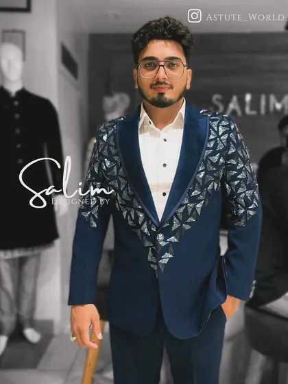 A client wearing a navy blue blazer with a velvet lapel and geometric silver embellishments. The triangular patterns give the jacket a modern, architectural feel.