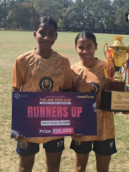 Two of our players posing with the runners-up trophy from the JMF Pink Cup, a symbol of their successful tournament run.