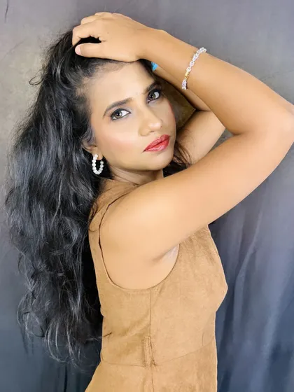 A bold and confident pose from the final look. The makeup is simple yet impactful, with a focus on glowing skin and a pop of color on the lips.
