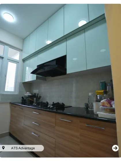 A two-tone modular kitchen with light blue upper cabinets and wood-finish lower cabinets. This combination creates a fresh and modern look.