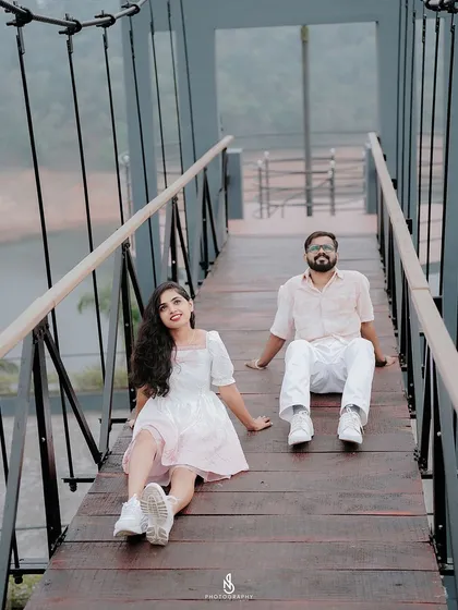 A relaxed moment, sitting together on the wooden planks of the bridge, enjoying the view.