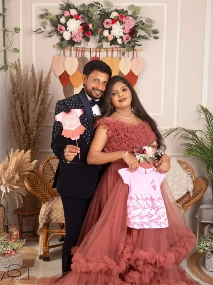 A sweet gender reveal moment! This couple announces they're expecting a girl with cute props, surrounded by the warm and rustic decor of the boho setup.
