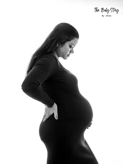 A simple, high-contrast black and white portrait focusing on the baby bump. This silhouette style is powerful and beautifully captures the physical transformation of pregnancy.