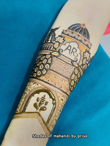 A close-up of the Ganesha and architectural elements on the arm. The combination of spiritual and traditional motifs creates a rich design.