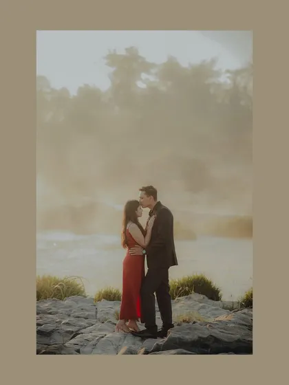 A stunning portrait with a misty, ethereal background. The groom's gentle kiss on the forehead is a timeless expression of love and care.