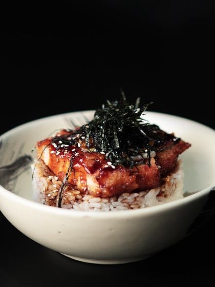 Our Teriyaki Chicken Don is a refined epicurean journey. It features tender, breaded chicken cutlets over a bed of fragrant rice, topped with nori and sesame seeds.