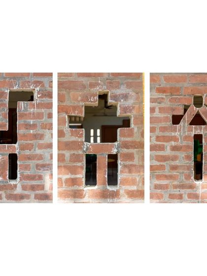 Playful openings in the brick wall of the Spastic Society classroom. These shapes, resembling animals and people, were created by strategically leaving out bricks, a simple yet creative way to add character and ventilation using a basic material.