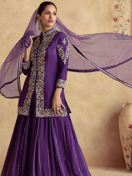 Feel like royalty in this violet premium silk palazzo suit. The intricate thread embroidery on the jacket-style top gives it a majestic look, perfect for a wedding or formal event.