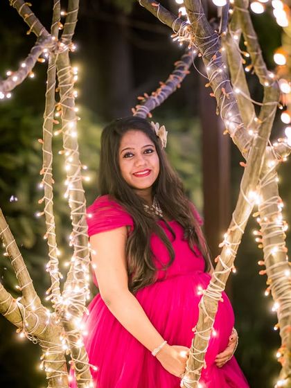A beautiful maternity portrait among the fairy-lit trees, highlighting the serene and magical ambiance of our gardens at night.