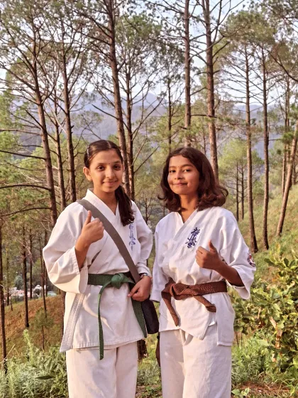 Two of my dedicated green and brown belt students, taking a moment during our mountain trek. Their thumbs-up says everything about the camp experience.
