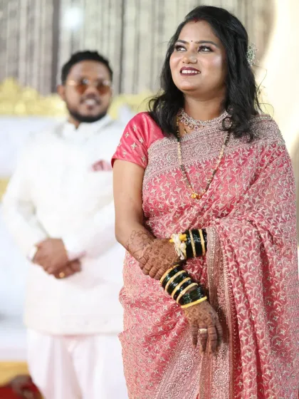 The groom looks on as his bride shines. Her reception makeup is elegant and sophisticated, designed to make her feel like a queen.