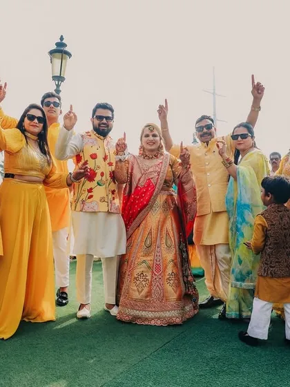 The whole squad together for the Haldi! This photo captures the bride and groom with their friends and family, all dressed in yellow and ready to celebrate with dhol beats.