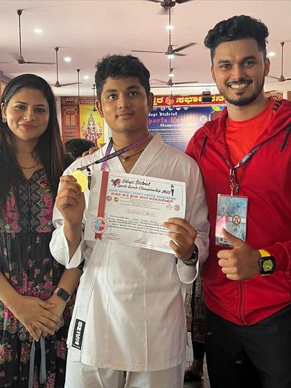 Celebrating a gold medal win at the 1st District Sports Karate Championship. This young champion has a bright future.