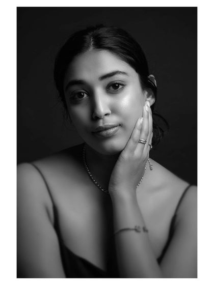 A quiet and thoughtful black and white portrait. The model's pose and expression convey a sense of introspection and peace.