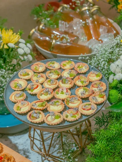 A platter of our delicate fruit tarts, filled with cream and topped with fresh kiwi, apple, and dragon fruit. These bites are a refreshing and elegant addition to any dessert table or high tea.