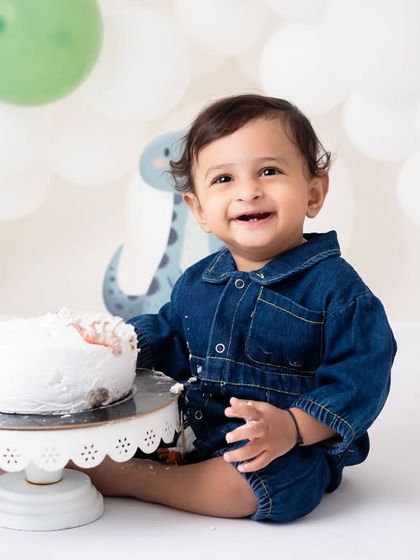 A sweet smile before the big smash. This "wild one" safari theme is a popular choice for boys' first birthdays, and the cute animal props add to the fun.
