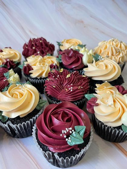 A set of custom floral cupcakes designed for an elegant event. I used a rich burgundy and soft yellow buttercream to pipe different styles of flowers, finished with sugar pearls and edible gold leaf for a touch of luxury.