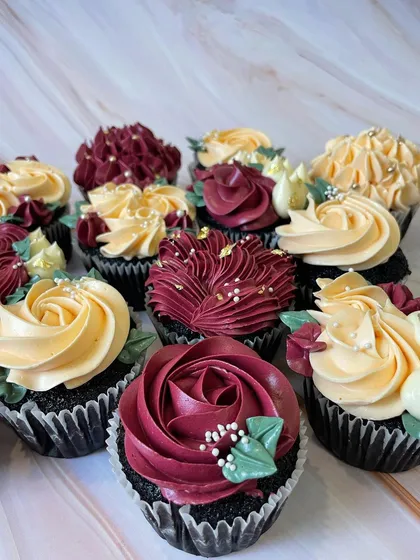 A set of custom floral cupcakes designed for an elegant event. I used a rich burgundy and soft yellow buttercream to pipe different styles of flowers, finished with sugar pearls and edible gold leaf for a touch of luxury.