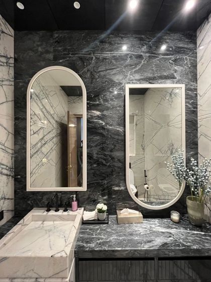 The dual mirrors and integrated marble sink in this Art Deco washroom showcase our attention to detail and commitment to creating a cohesive, luxurious experience.
